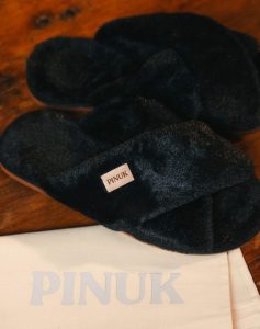 Pantufa Anatômica X Preta felpuda com tiras cruzadas sobre saquinho de tecido Pinuk