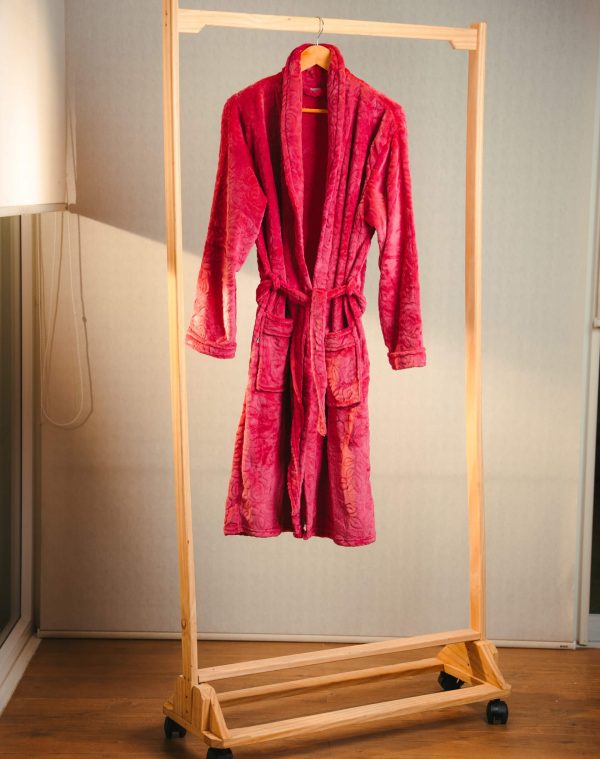 Roupão Lady Azaleia vermelho-framboesa com faixa e bolsos, pendurado em arara de madeira com rodinhas