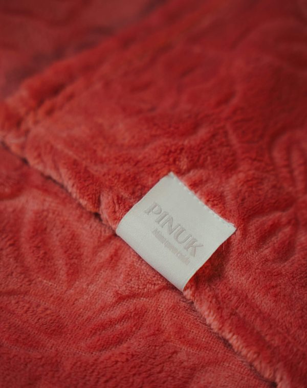 Manta Lady Blush rosa-coral felpuda com relevo floral e etiqueta Pinuk branca em destaque